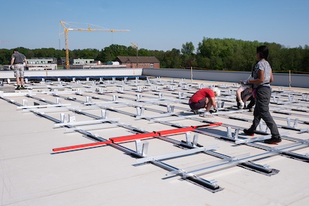 Mitglieder von Olegeno beim Installieren der PV-Anlage auf dem Dach der Quartiersgarage in Helleheide.