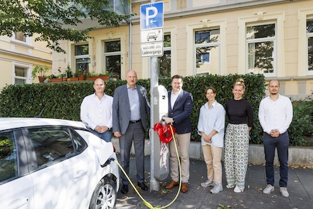 Braunschweigs Oberbürgermeister Thorsten Kornblum (2.v.l.) nimmt einen Ladepunkt an einer Straßenlaterne in Betrieb.